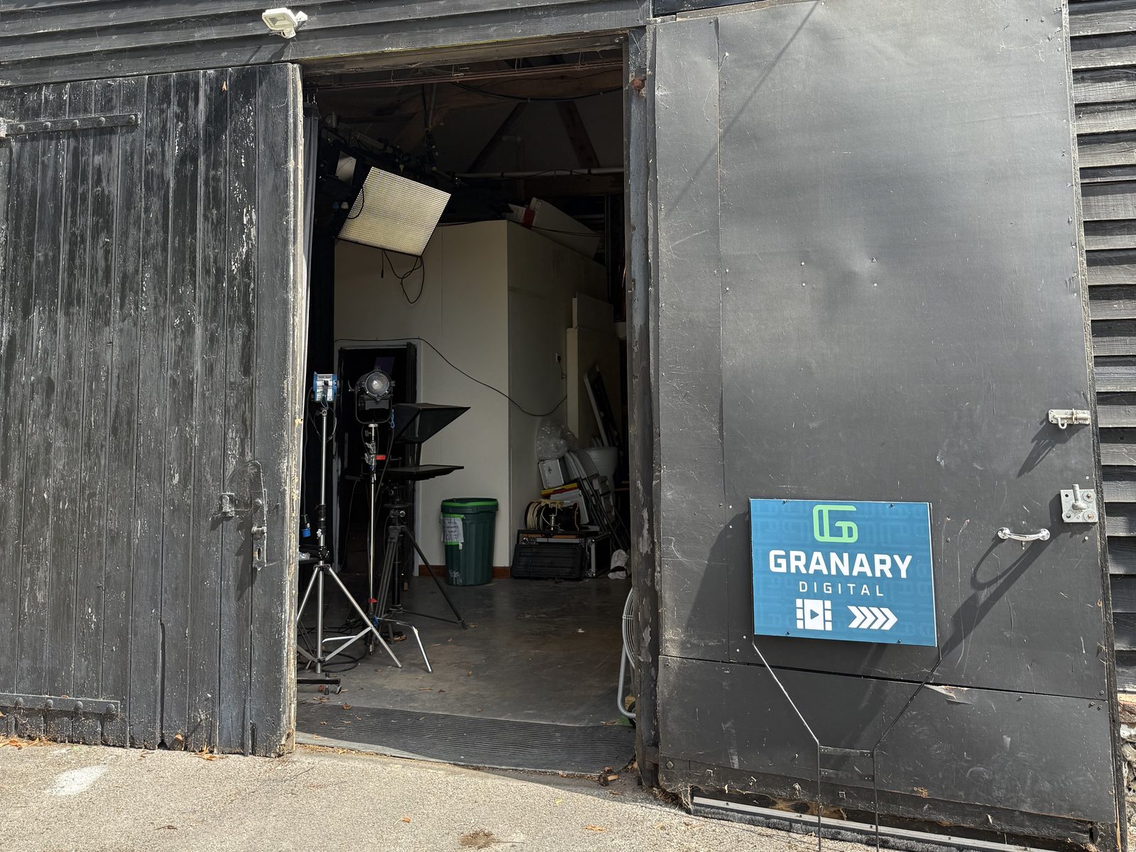 The barn's double doors at the Chichester studio, open onto the car park with lighting kit inside