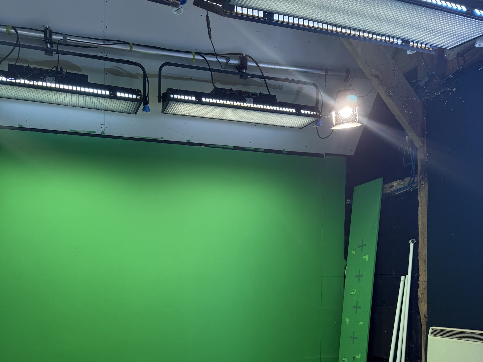 The green screen space: a chroma green wall under soft light banks, with a tracking-marked flat